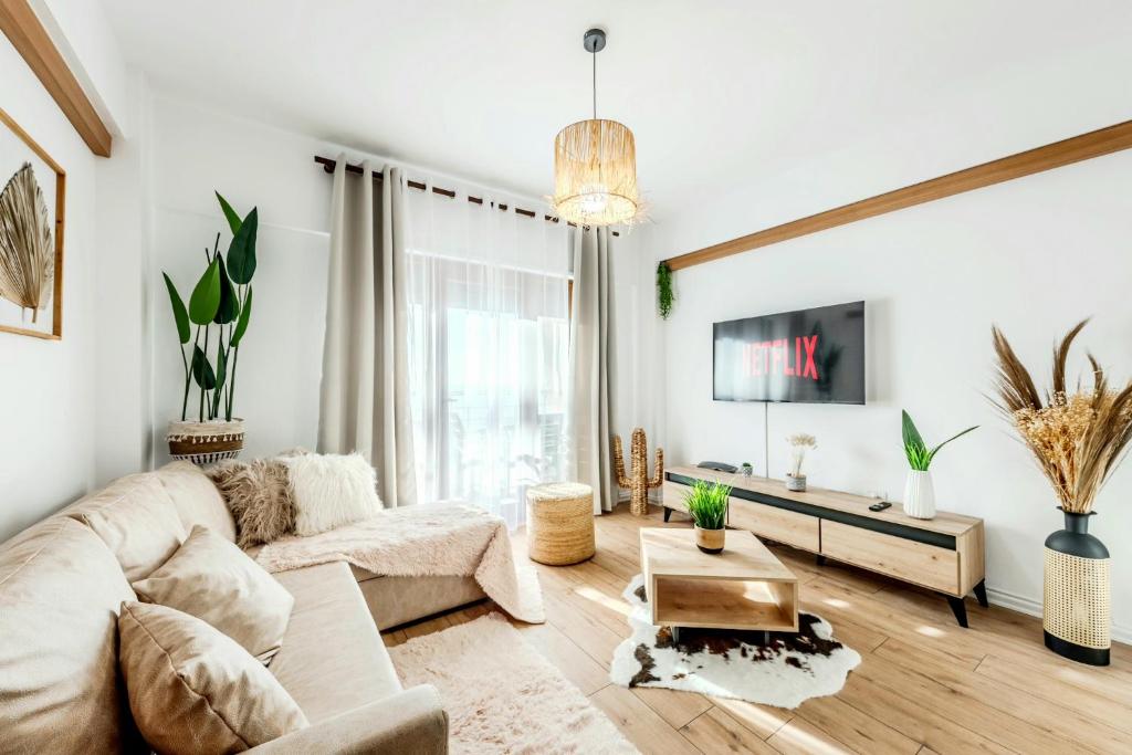 a living room with a couch and a tv at Sophie Dream Apartment, City Center , Beachfront in Durrës