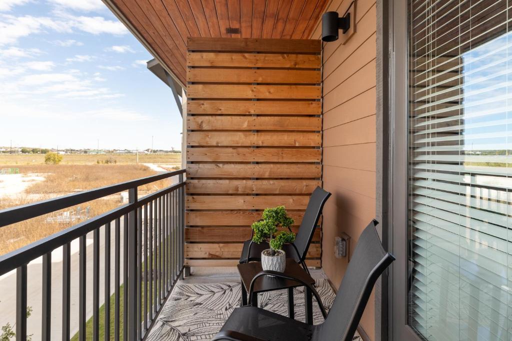 a balcony with two chairs and a wooden wall at Stunning 1BD apt in Fort Worth
