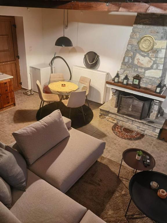 a living room with a couch and a fireplace at Traditional Stone Cottage in Palio Elatohori in Elatochori