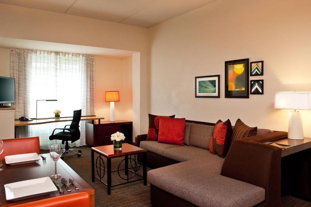 a living room with a couch and a table at Residence Inn by Marriott Syracuse Downtown at Armory Square in Syracuse