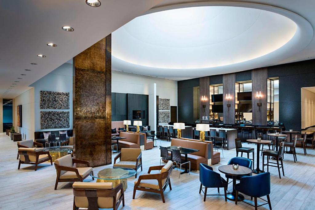 um átrio de um hotel com mesas e cadeiras em Marriott Dallas/Fort Worth Westlake em Westlake