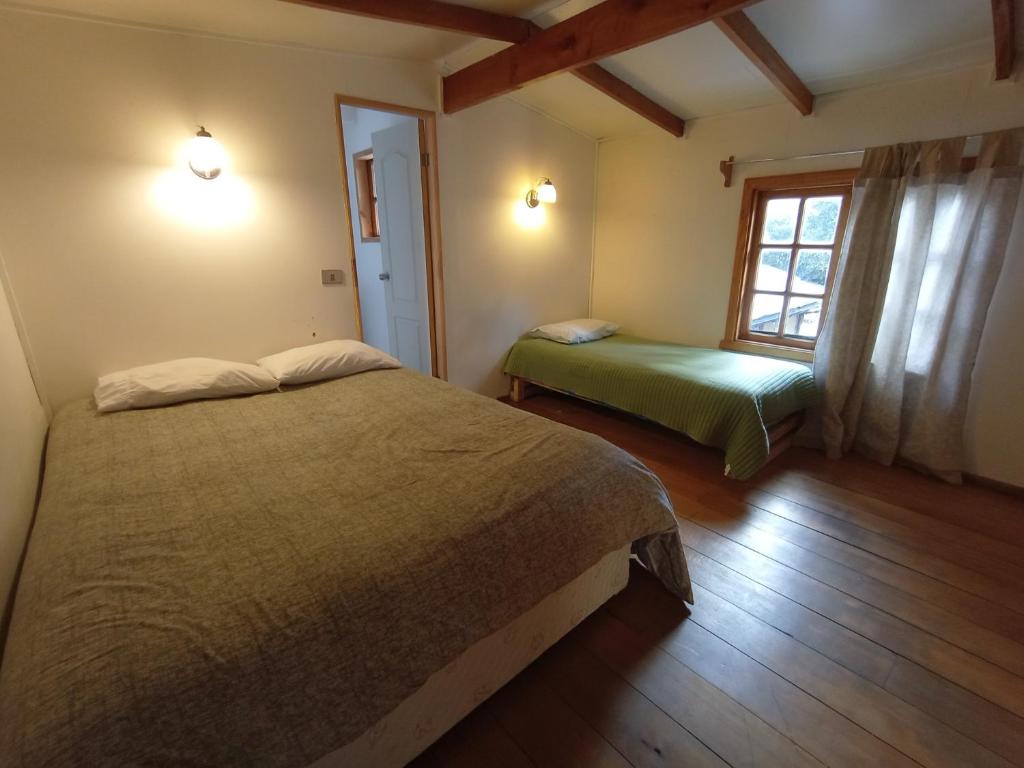um quarto com 2 camas e uma janela em Hostal Repu em Pucón