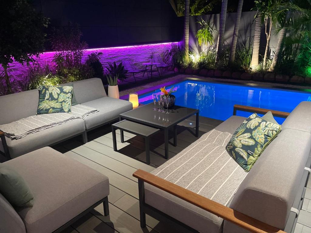 un patio con divani, tavolo e piscina di Villa de Standing à Nouméa a Noumea