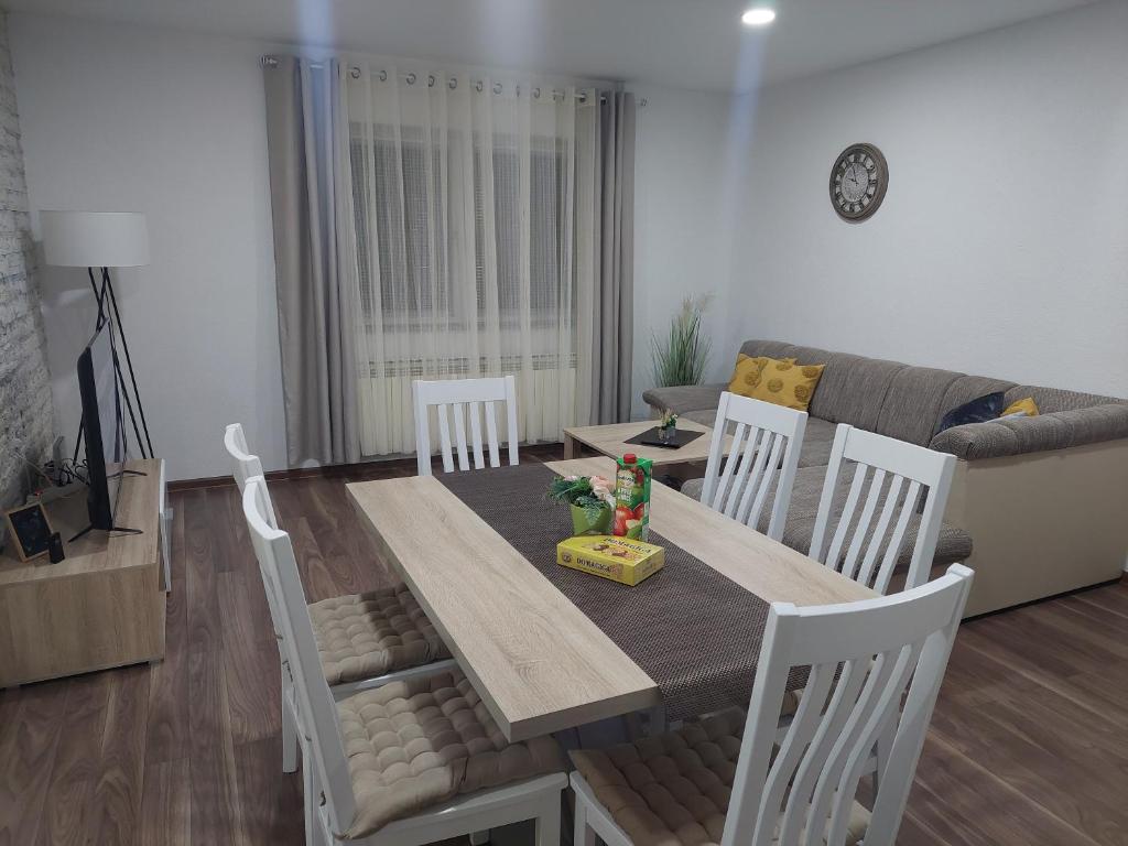ein Wohnzimmer mit einem Tisch, Stühlen und einem Sofa in der Unterkunft Apartman Danijela in Otočac