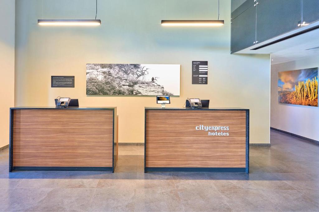 une paire de bureaux de réception dans une pièce dans l'établissement City Express by Marriott Caborca, à Heroica Caborca