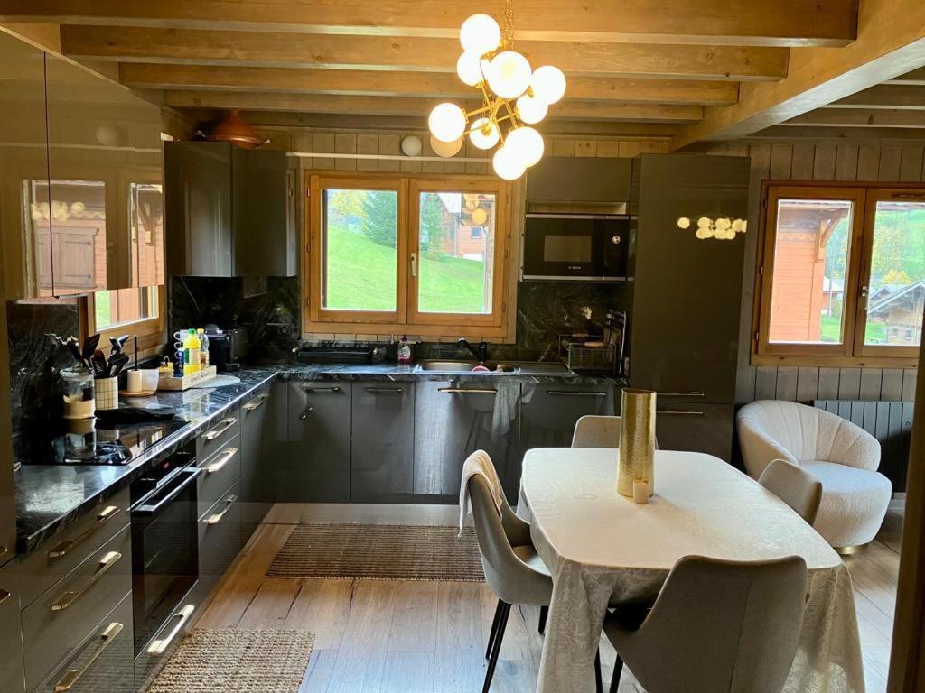 a kitchen with a table and a table and chairs at Chalet luxueux in Châtel