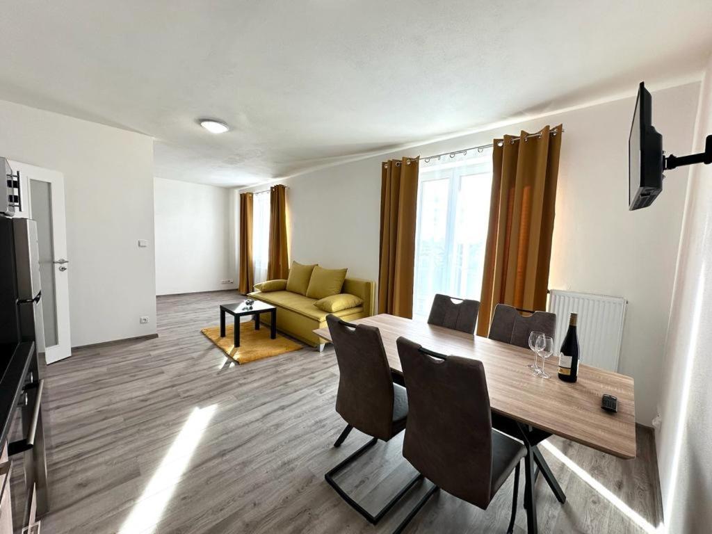 - un salon avec une table, des chaises et un canapé dans l'établissement Sky Apartments 505, à Plzeň