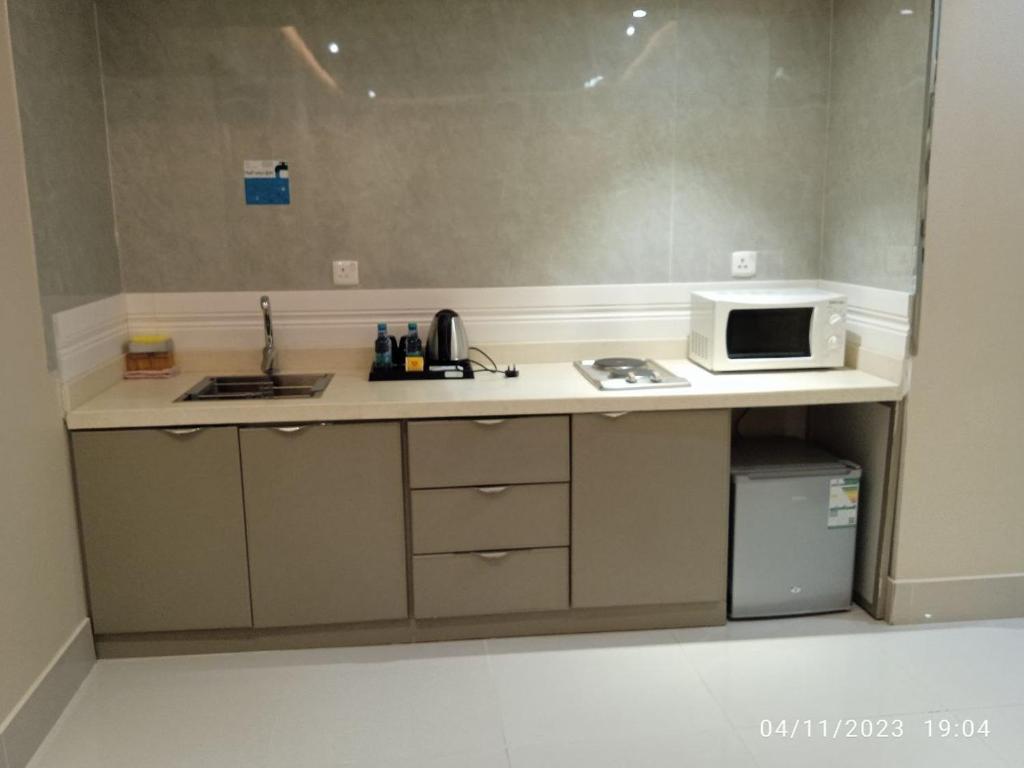 a kitchen with a sink and a microwave on a counter at الماسةالتاج للشقق الفندقية in Hail