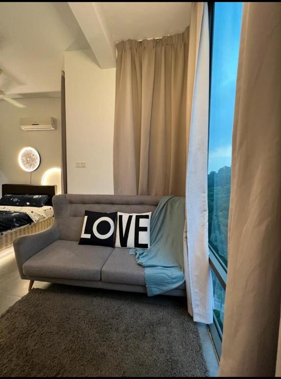 ein Wohnzimmer mit einem Sofa und einem Liebeskissen in der Unterkunft Nebulosa @ Empire Damansara in Petaling Jaya