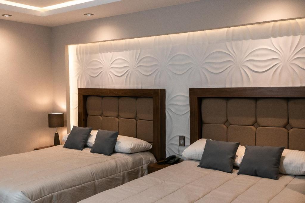 En eller flere senge i et værelse på Hotel Arthemisa