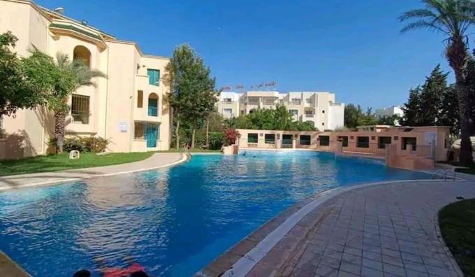 a large swimming pool in front of a building at Appartement résidence Port yasmine hammamet in Hammamet
