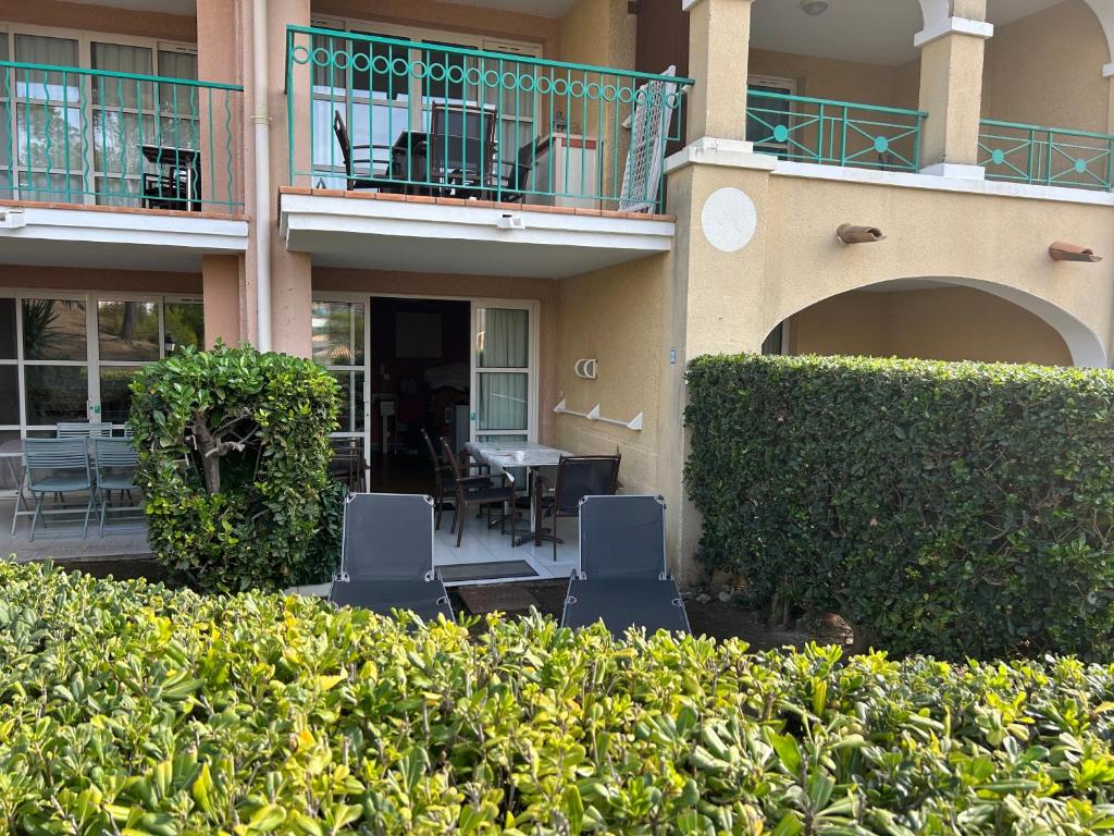 une maison avec deux chaises et une table sur un patio dans l'établissement Appartement 2 pièces climatisé en rez-de-jardin Cap Esterel Agay, à Agay
