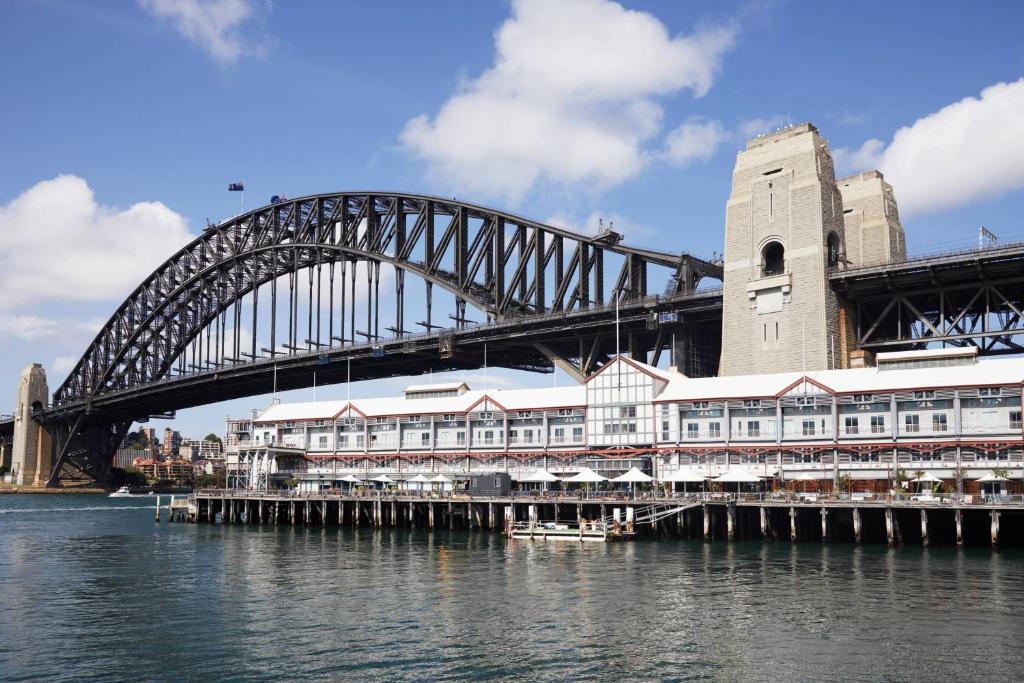 a bridge over a body of water with a building at Pier One Sydney Harbour, Autograph Collection in Sydney