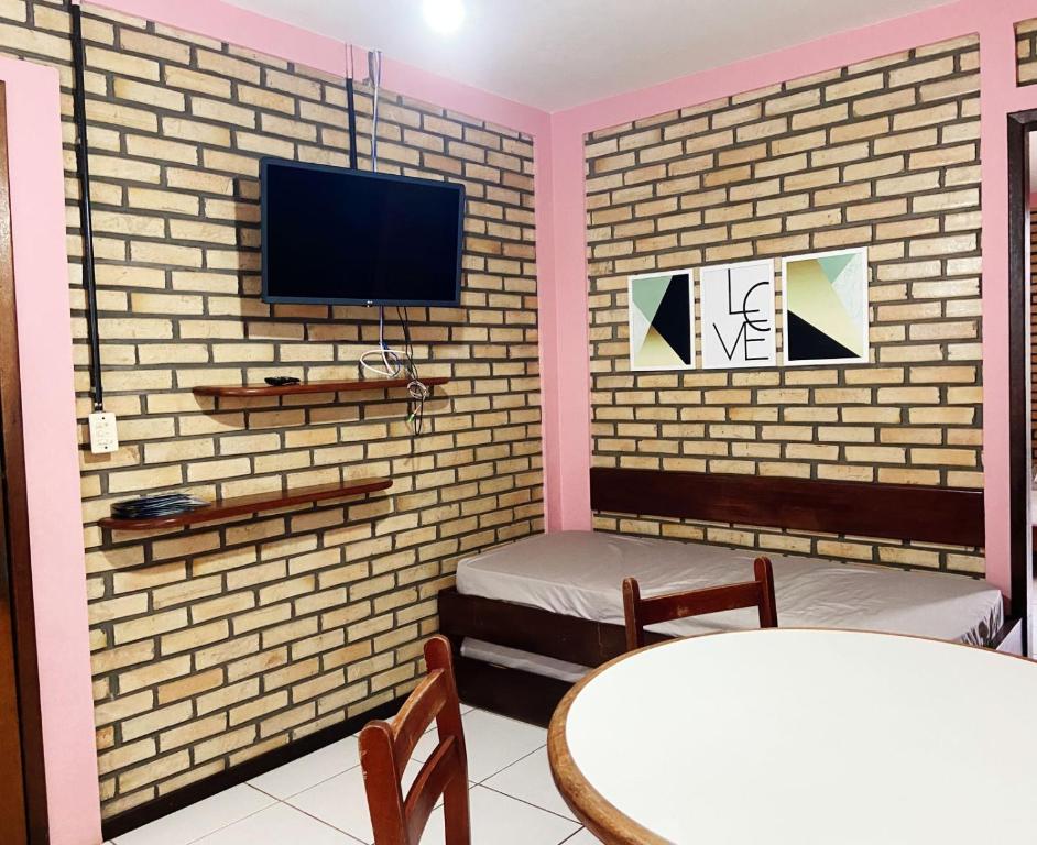 uma sala de estar com televisão numa parede de tijolos em La Serena em Florianópolis