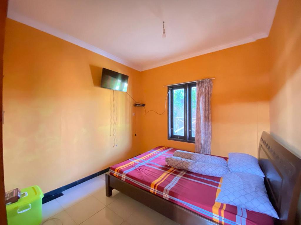 a bedroom with a bed and a window at Villa Satita Murah Batu in Batu