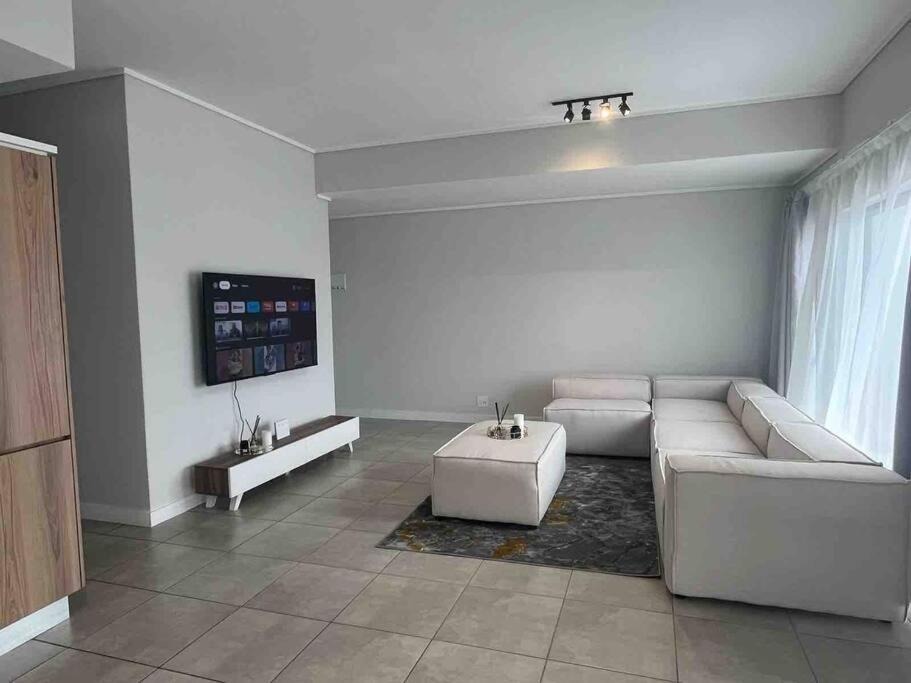 a living room with a couch and a table at 3 Elizabeth Place Luxury Penthouse - Beautiful self catering 2 bedroom unit next to the Lagoon with free WiFi - swimming pool gym and restaurant - Perfect for a small family in Midrand