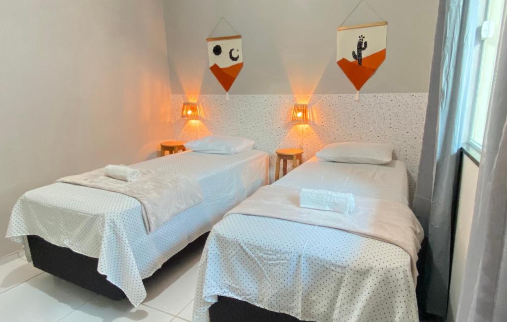 two beds in a room with lights on the wall at Casa Sóumi - Ubajara/CE in Ubajara
