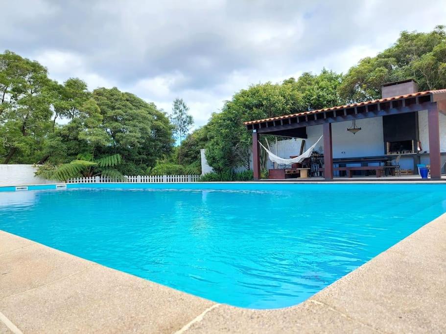 a blue swimming pool in front of a house at La Finca de Ananás - House in Ponta Delgada