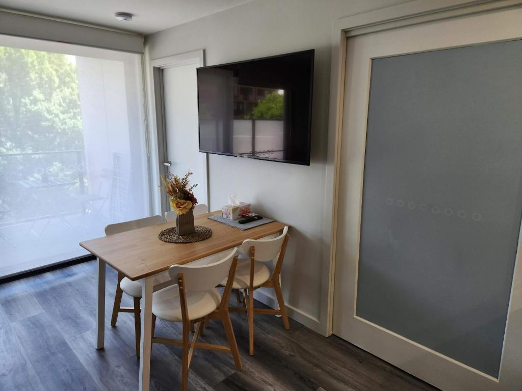 d'une salle à manger avec une table, des chaises et une fenêtre. dans l'établissement Home@Braddon, à Canberra