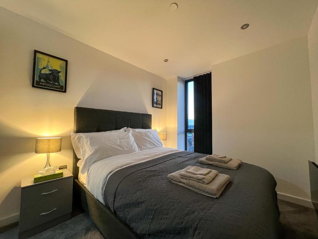 a bedroom with a bed with two towels on it at Elmardi Residence - 2 Bedroom Apartment City Centre in Birmingham