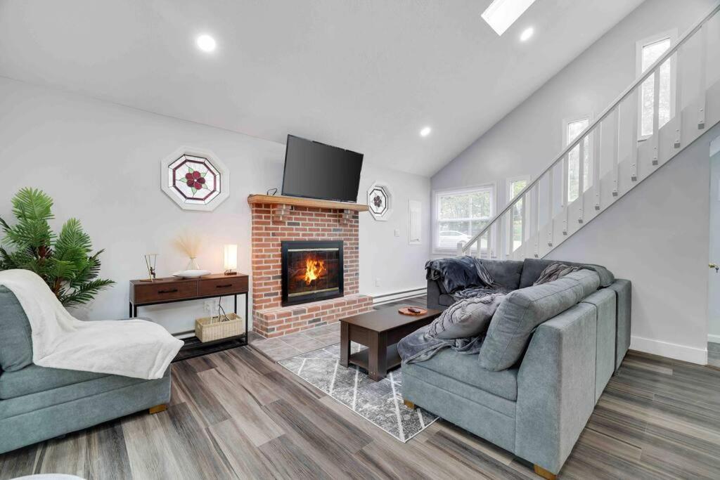a living room with a couch and a fireplace at Cozy, Spacious House *New*InTheCommunity+Fire Pit in Tobyhanna