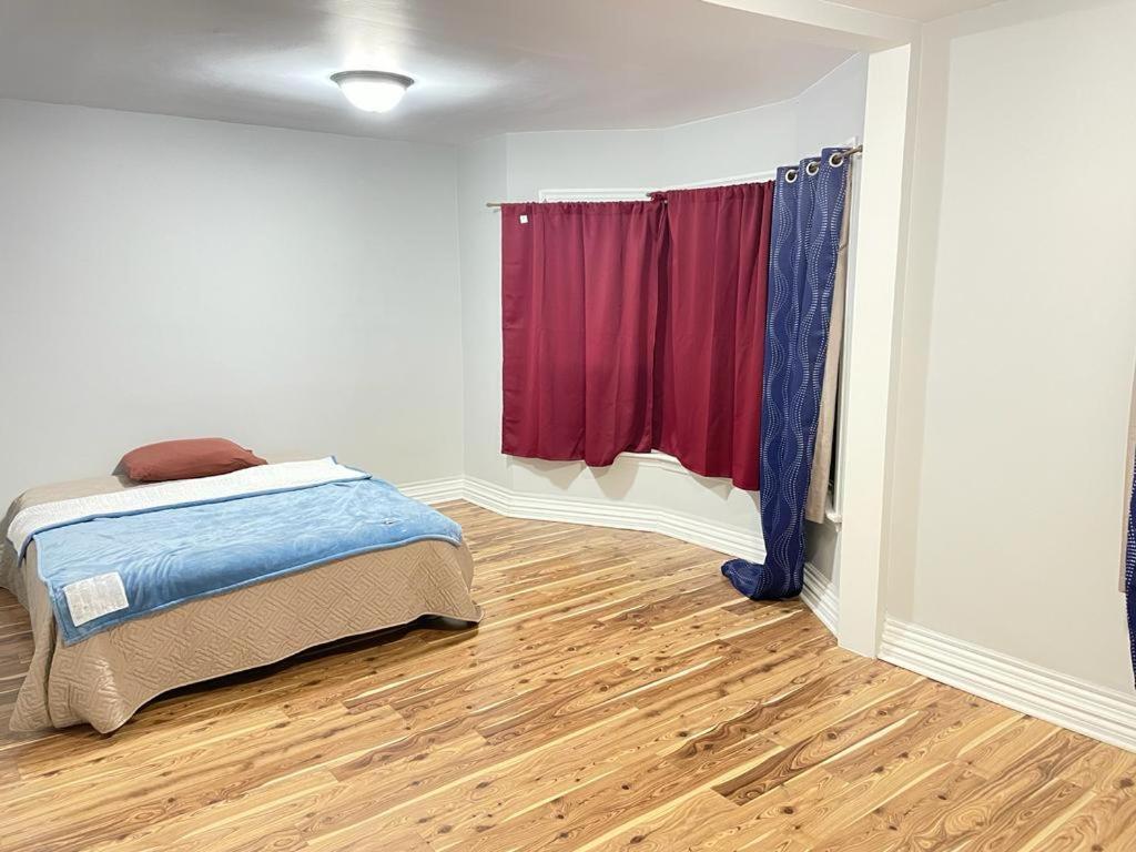 a bedroom with a bed and a red window at Cozy place to rest in Hamilton