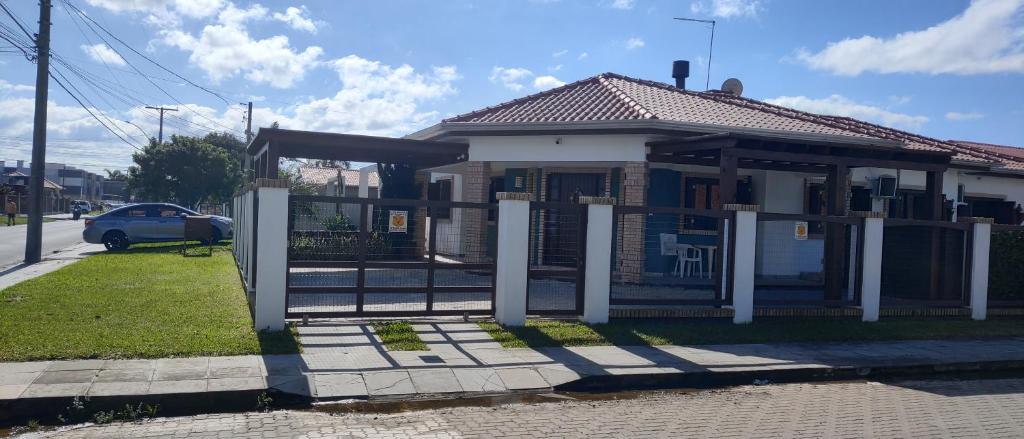 a house with a gate in front of it at CENTRO DE XANGRI-LÁ COM PISCINA in Xangri-lá