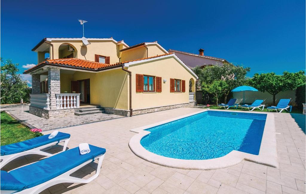 a villa with a swimming pool in front of a house at Beautiful Home In Fazana With Kitchen in Fažana