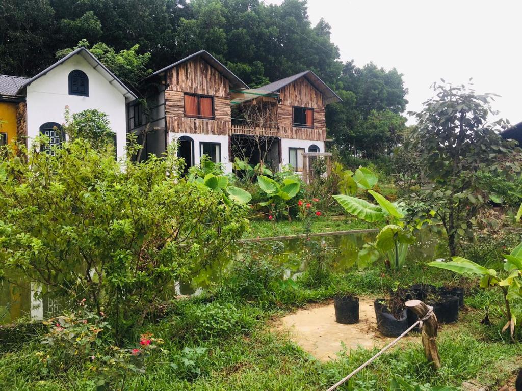 a house in the middle of a garden at Stella Đồng Lâm Homestay in Làng Ben