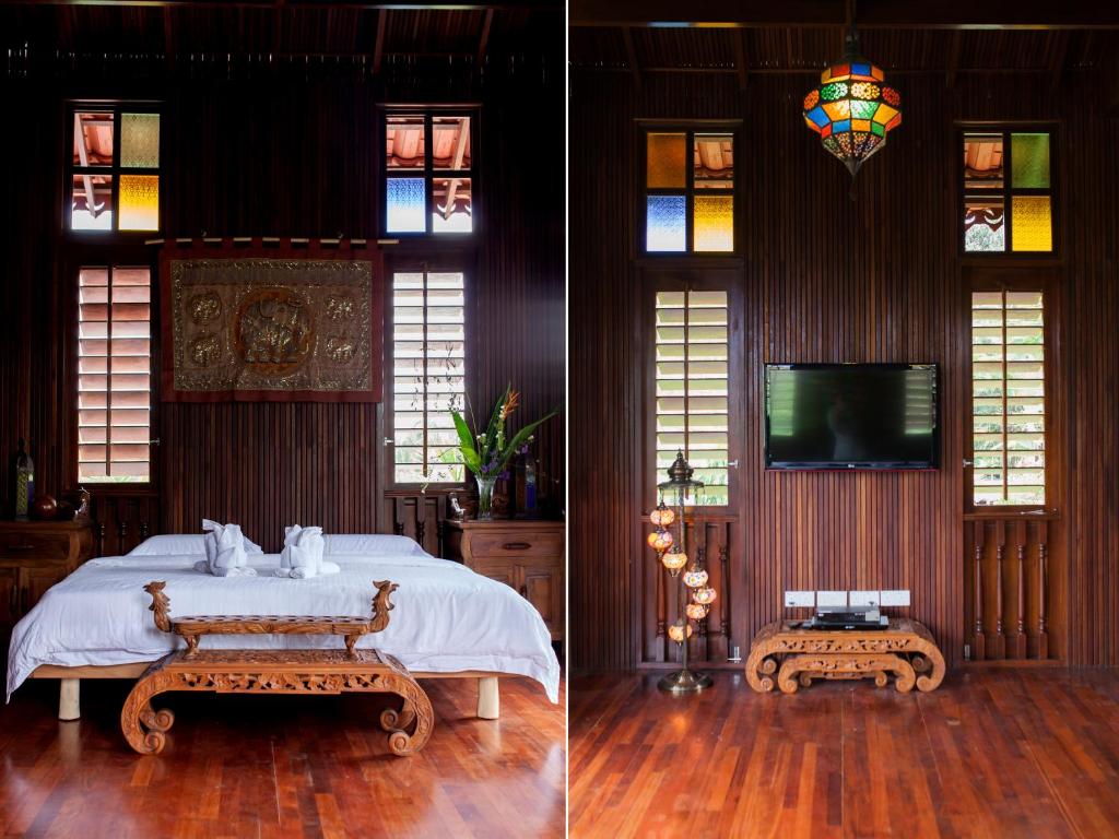 a bedroom with a bed and a tv and stained glass windows at Arundina in Ipoh