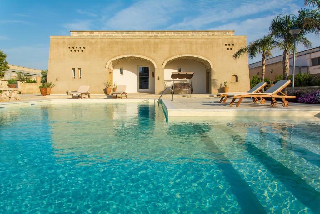 a swimming pool in front of a house at Relais Tenuta Campì in Martano