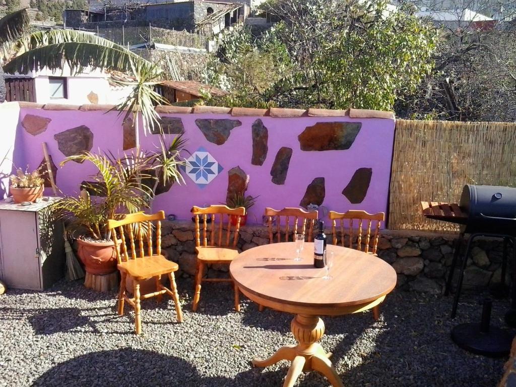 a table and chairs in front of a purple wall at Casitas El Paso in El Paso