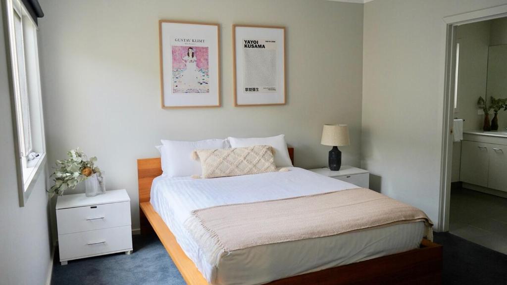 - une chambre avec un lit et deux photos sur le mur dans l'établissement Honeysuckle St Cottage Central Location Sleeps 8 - To be removed, à Bendigo