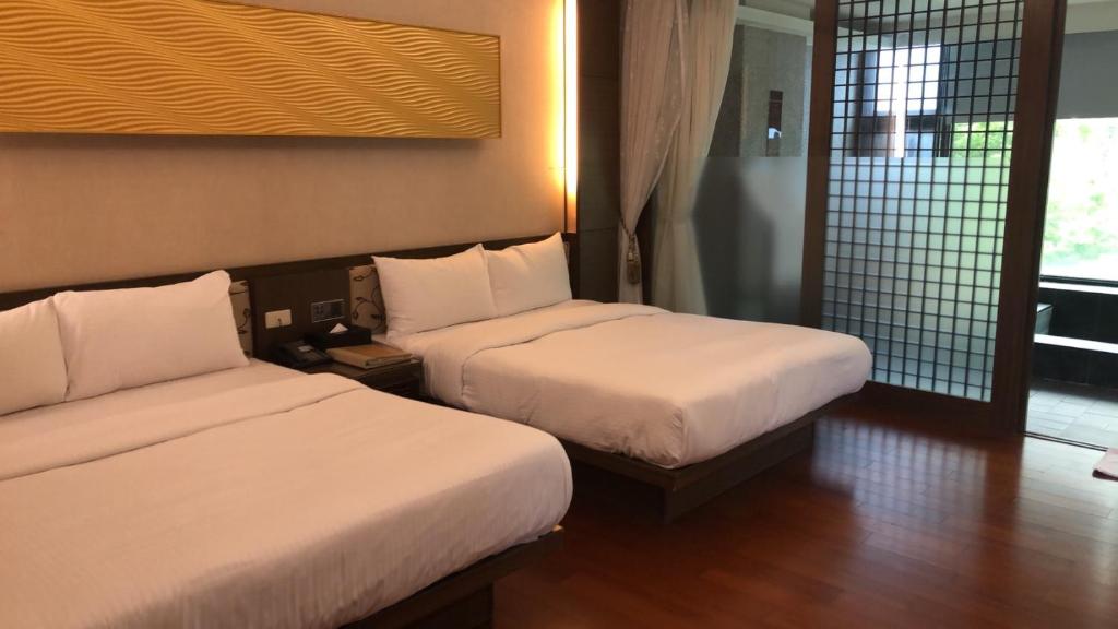 a hotel room with two beds and a window at Tangyue Resort in Tai&#39;an
