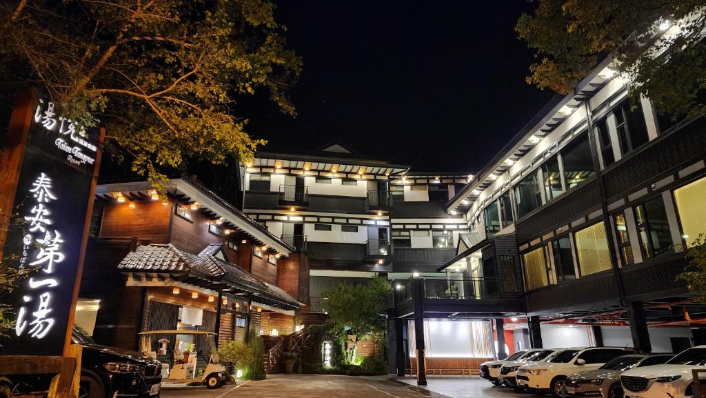 a building with cars parked in front of it at night at Tangyue Resort in Taian