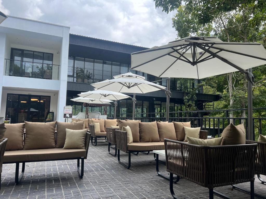 a group of chairs and umbrellas in front of a building at Tangyue Resort in Tai&#39;an