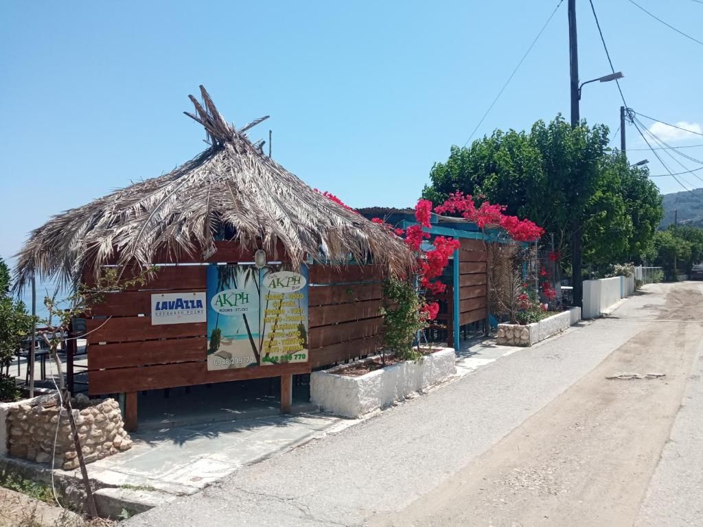 een kleine hut met een rieten dak op een straat bij Akri Rooms in Akrata