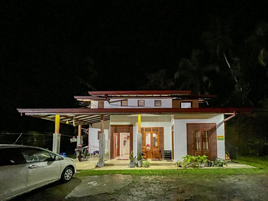 a small house with a car parked in front of it at Sinharaja River Face holiday in Nelluwa