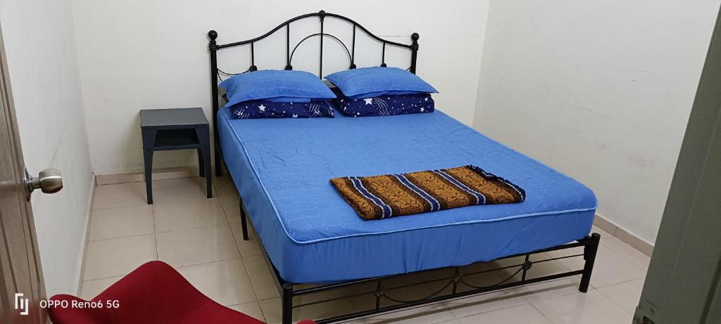 Bett mit blauer Bettwäsche und blauen Kissen in der Unterkunft RW segamat homestay in Segamat
