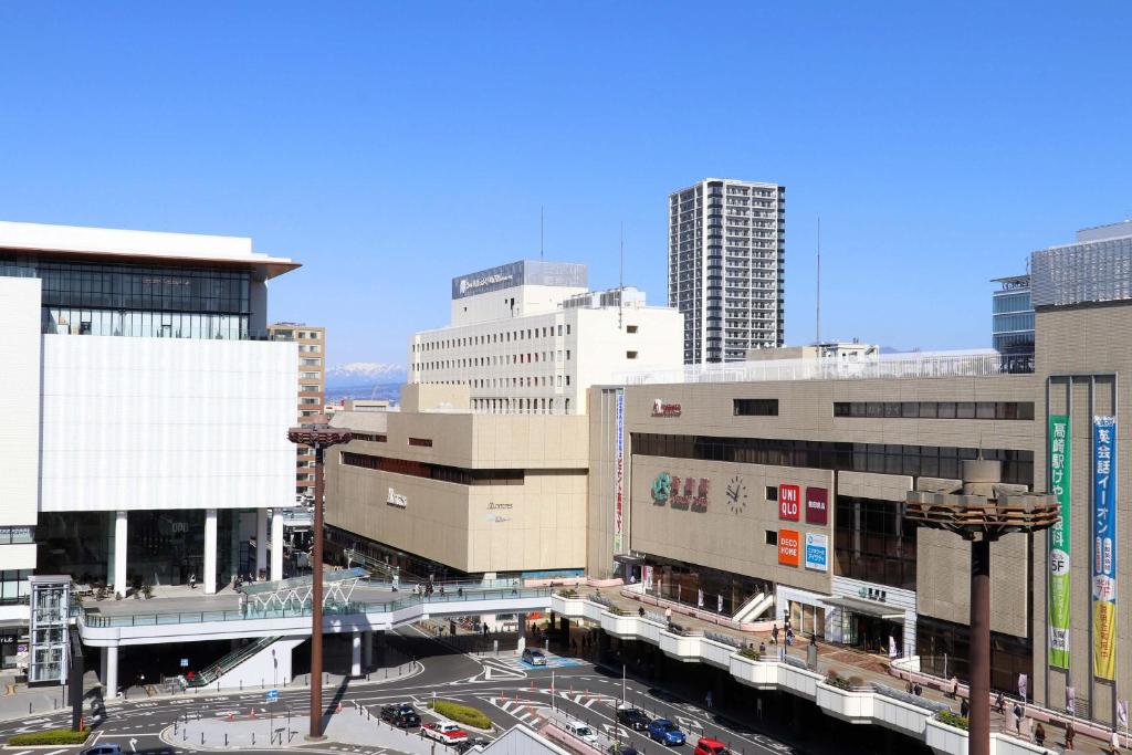 a city with tall buildings and a street with cars at Hotel Metropolitan Takasaki in Takasaki