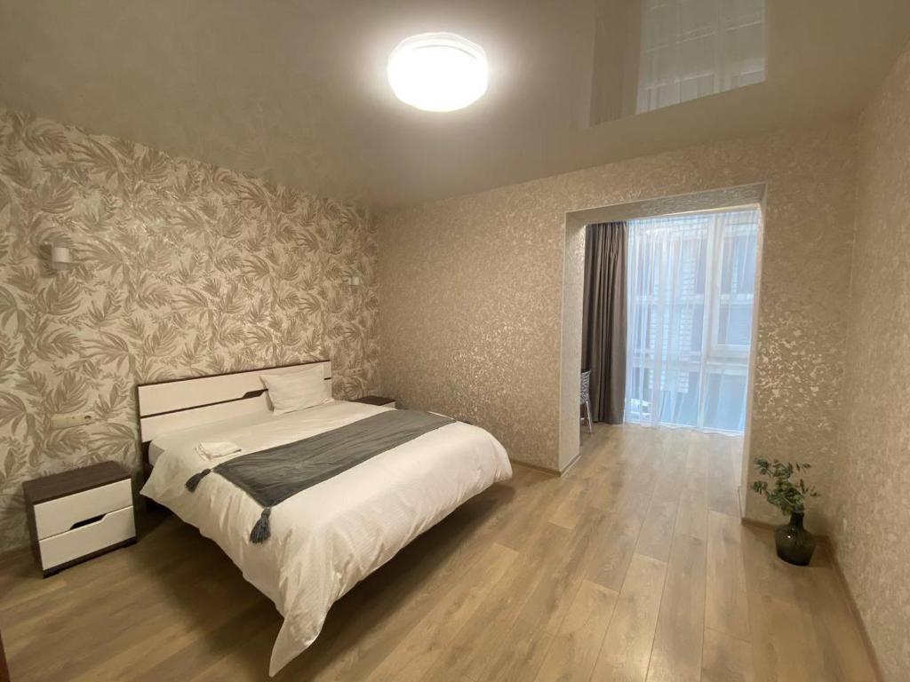 um quarto com uma cama e uma grande janela em Atlant luxury Big Family Perlina Apart on Golovna з двома санвузлами поряд з ТЦ Депот em Chernivtsi