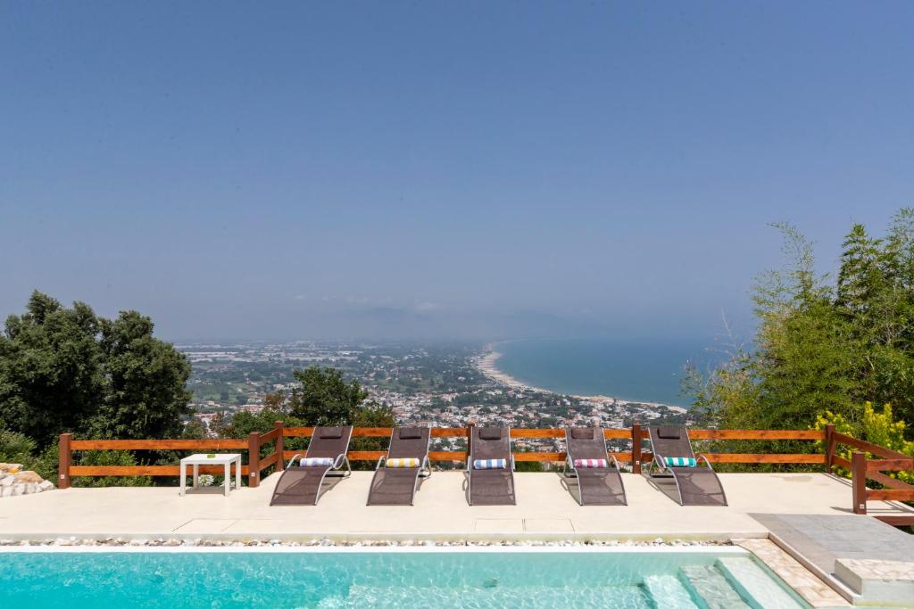 un grupo de sillas sentadas junto a una piscina en Italian Coastal Charm: Villa in San Felice Circeo en San Felice Circeo
