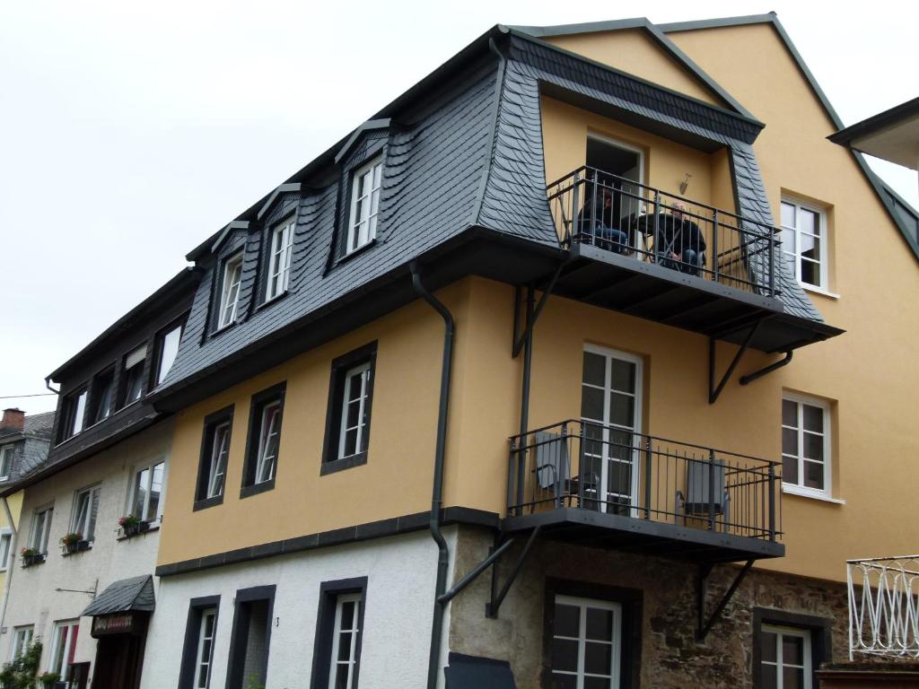 ein gelbes und weißes Gebäude mit einem Balkon in der Unterkunft Mosel-Apart Rudorfer in Valwig