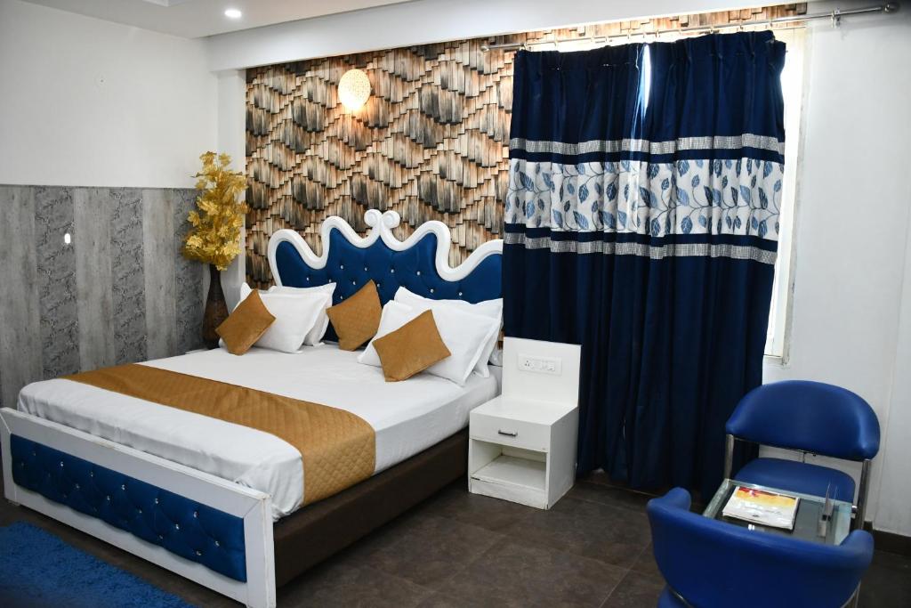 Hotel Royal Comfort Inn في Pinjaur: غرفة نوم بسرير كبير وكرسي ازرق
