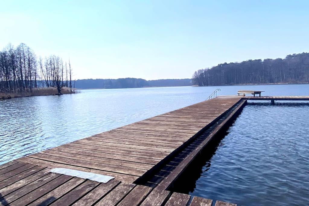 a wooden dock with a bench sitting on top of a lake at Romantik-Ferienhaus -Vier Sterne- idyllische Lage in Marienwerder