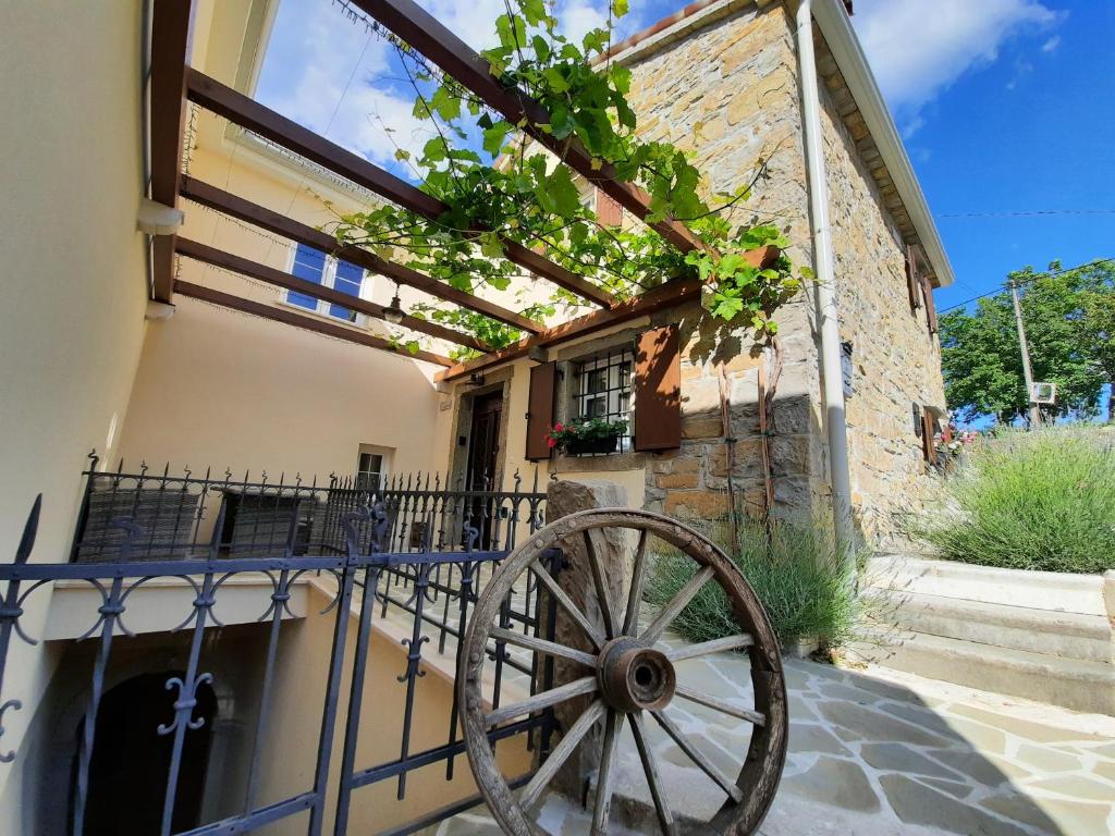 una rueda de carruaje de madera delante de un edificio en Guest house Nostalgia, en Gračišče