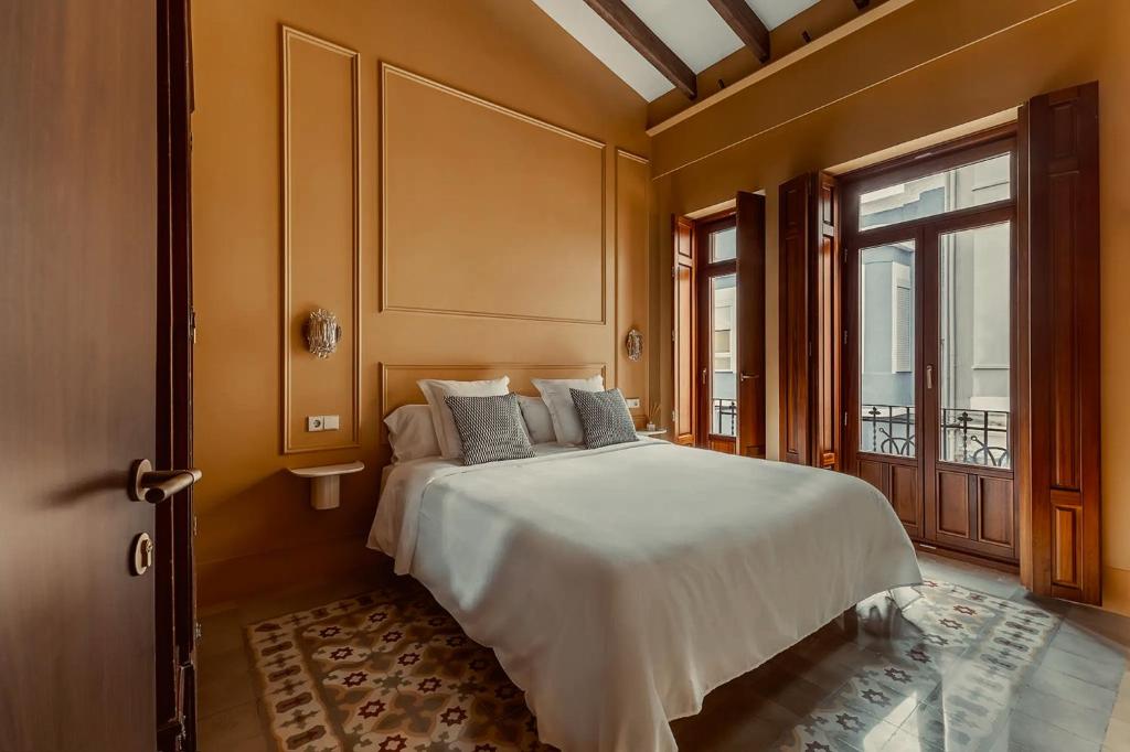a bedroom with a large white bed and a window at La Novieta Boutique Hotel - Adults Only in Valencia