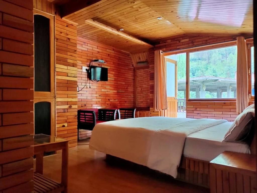 ein Schlafzimmer mit einem großen Bett und einem Fenster in der Unterkunft The yerpa Hotel in Kasol