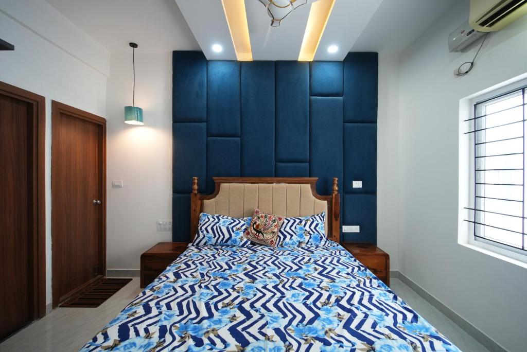 una camera con un letto con una parete blu di Aayushman Luxury Homes a Sarjāpur