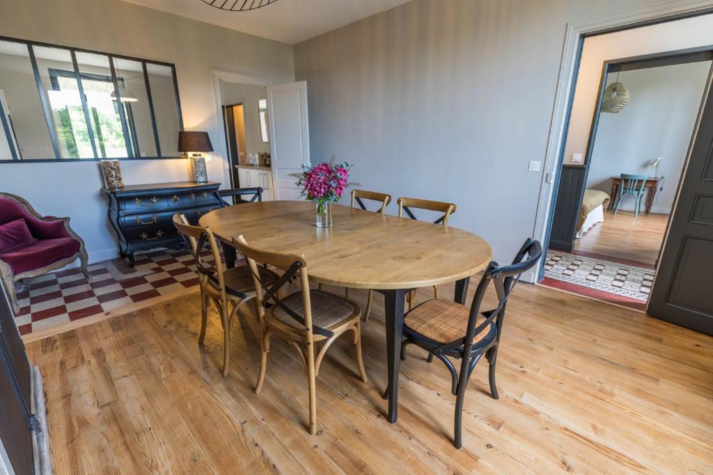 uma sala de jantar com uma mesa de madeira e cadeiras em La maison d'à côté em Mont-de-Marsan